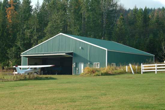 Farm building with a bifold hanger door for aircraft storage